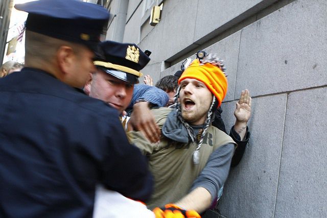 A protester gets arrested for "jumping" the barricade.
